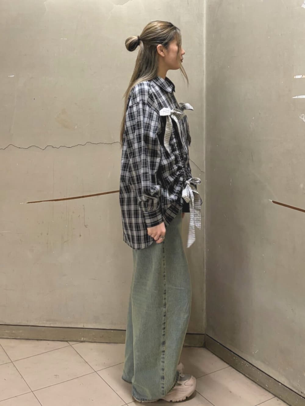ブルー系のデニムパンツ、ブラック系のシャツ/ブラウスを着用したレディースの春コーディネートの3枚目の写真