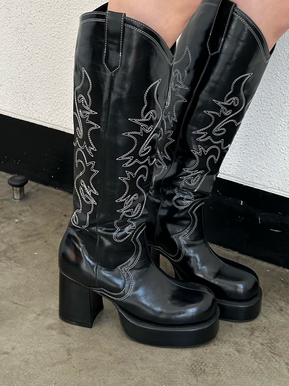 ブラック系のブーツ、グリーン系のスカート、ブラック系のパーカーを着用したレディースの冬コーディネートの7枚目の写真