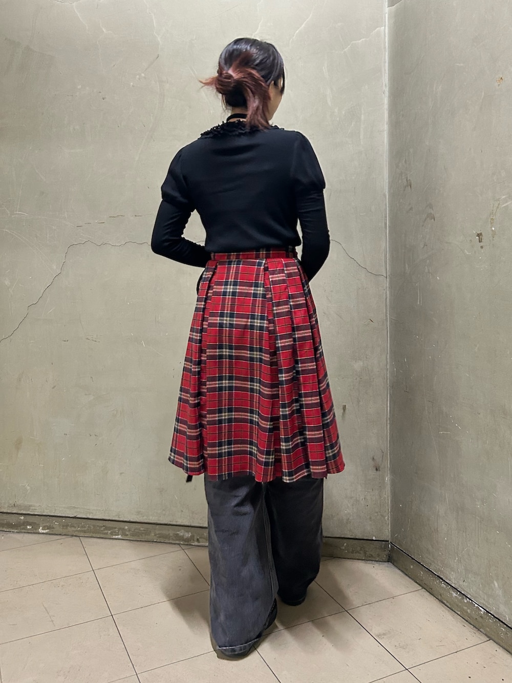 ブラック系のブーツ、ブラック系のTシャツ/カットソー、レッド系のスカートを着用したレディースの秋コーディネートの3枚目の写真