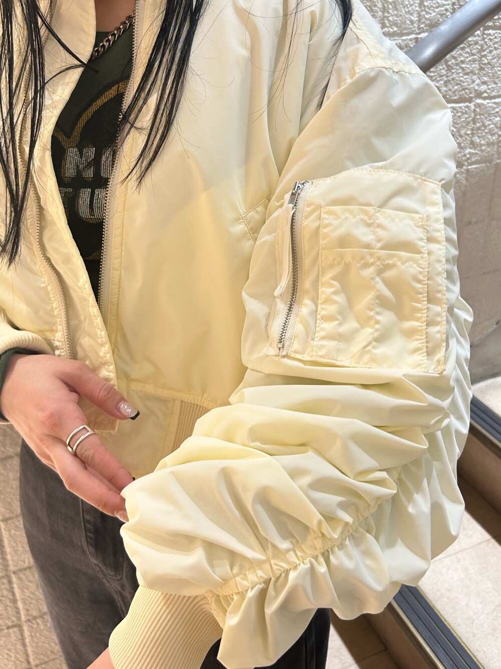 ベージュ系のブーツ、ブラック系のデニムパンツ、ホワイト系のMA-1を着用したレディースの秋コーディネートの7枚目の写真