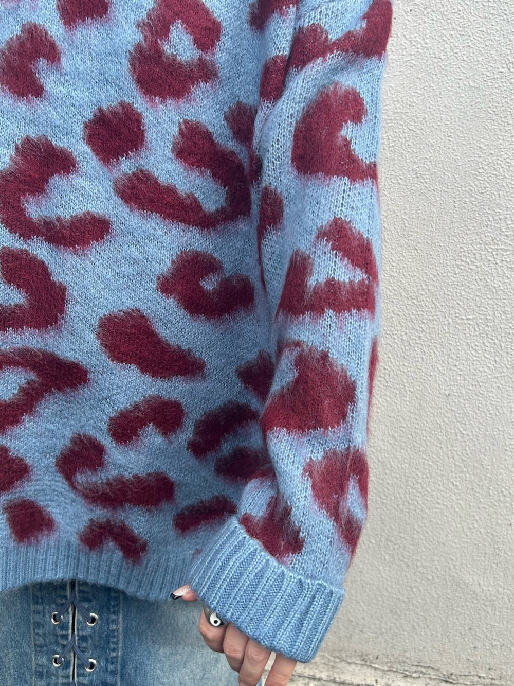 ブラック系のブーツ、ブルー系のデニムパンツ、ブルー系のニット/セーターを着用したレディースの秋コーディネートの4枚目の写真