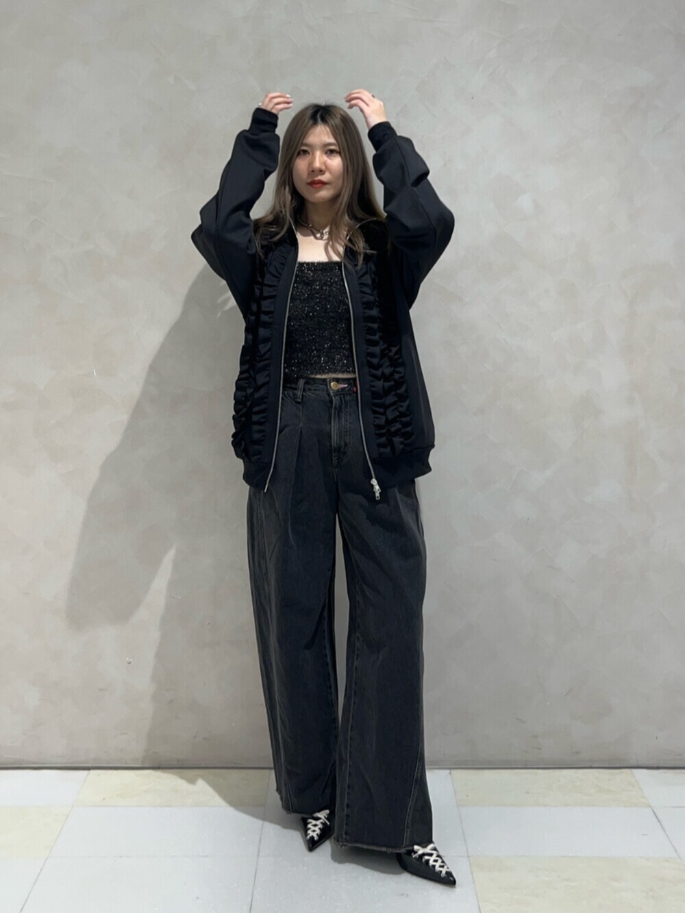 ブラック系のパンプス、ブラック系のデニムパンツ、ブラック系のアンサンブルを着用したレディースの秋コーディネートの5枚目の写真