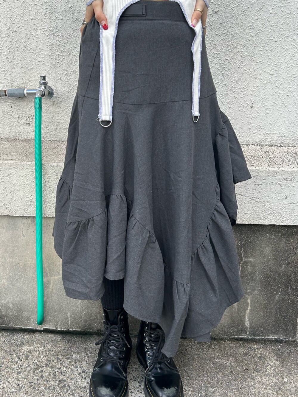 ブラック系のブーツ、ホワイト系のTシャツ/カットソー、グレー系のスカートを着用したレディースの秋コーディネートの9枚目の写真