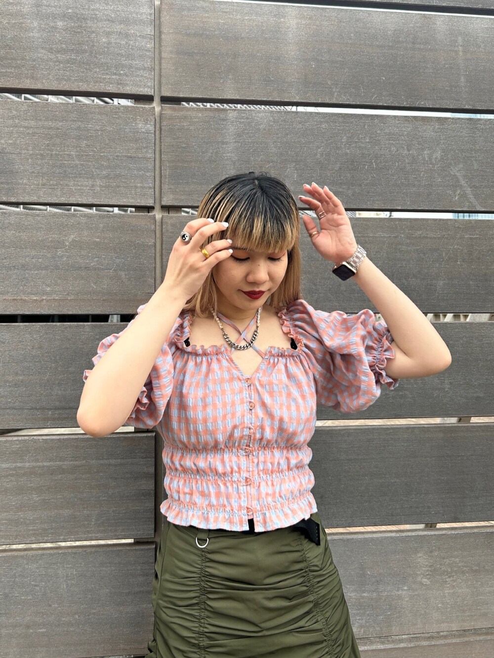 ブラック系のブーツ、オレンジ系のシャツ/ブラウス、グリーン系のスカートを着用したレディースの夏コーディネートの4枚目の写真