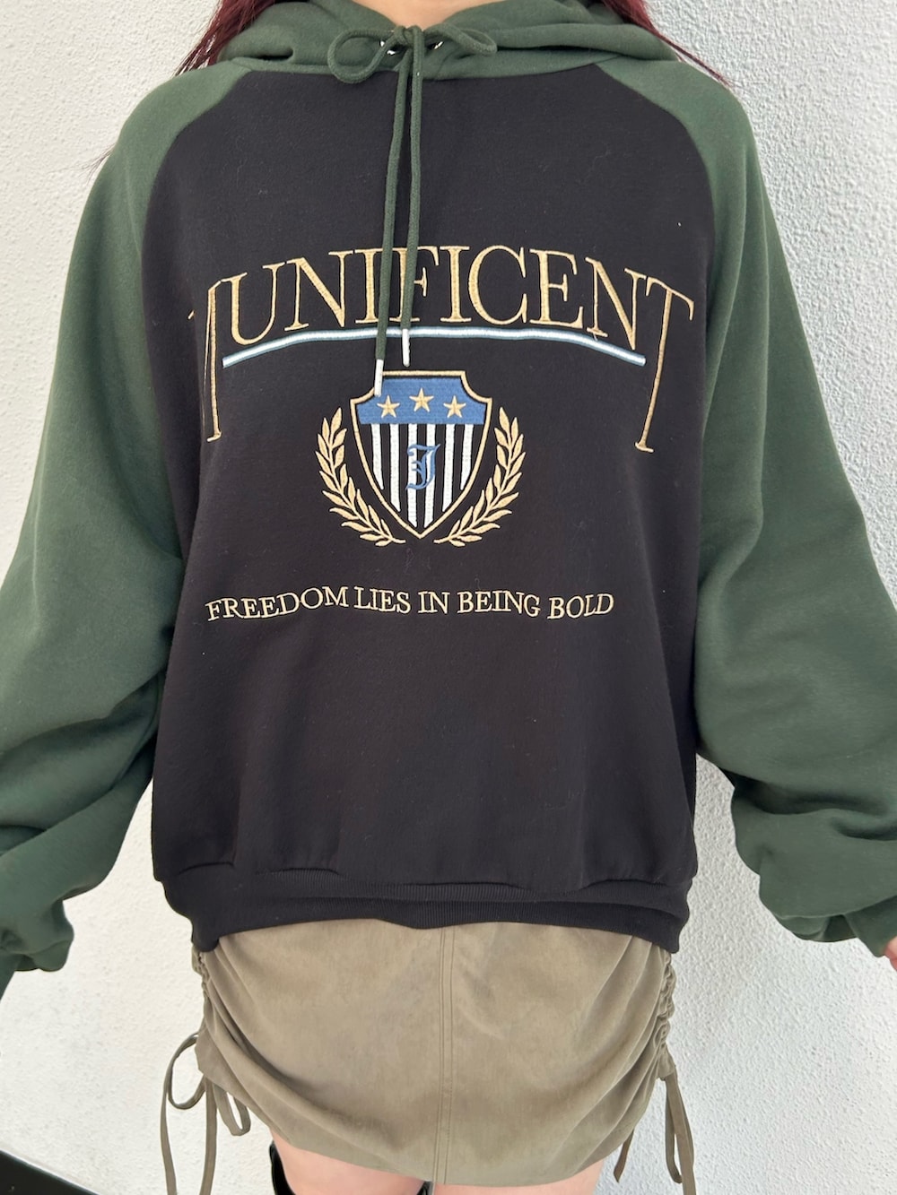 ブラック系のブーツ、グリーン系のスカート、ブラック系のパーカーを着用したレディースの冬コーディネートの5枚目の写真