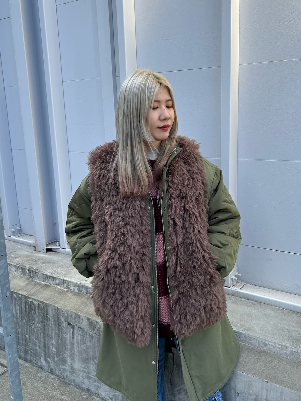 グリーン系のモッズコート、レッド系のニット/セーター、ホワイト系のTシャツ/カットソーを着用したレディースの秋コーディネートの5枚目の写真