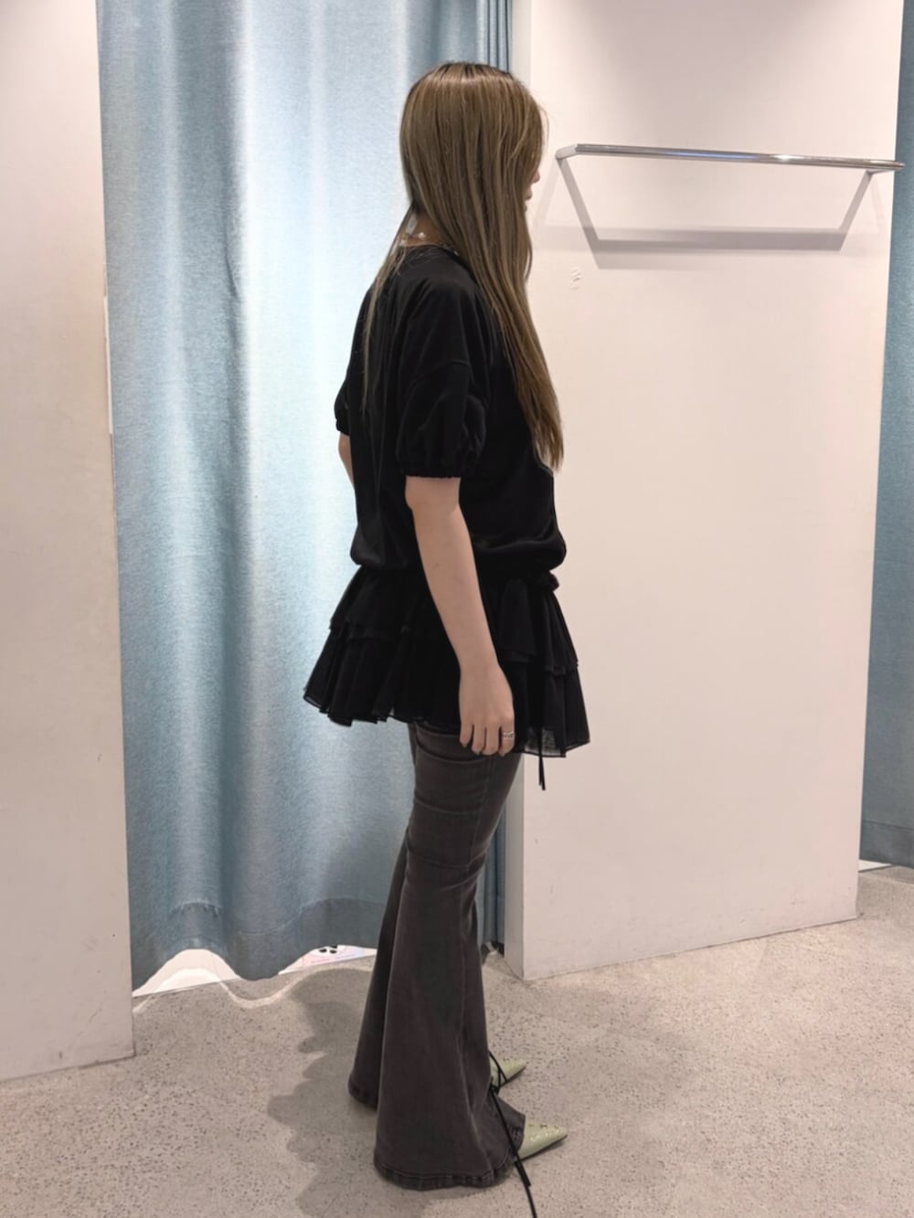 グリーン系のパンプス、ブラック系のデニムパンツ、ブラック系のワンピースを着用したレディースの春コーディネートの2枚目の写真