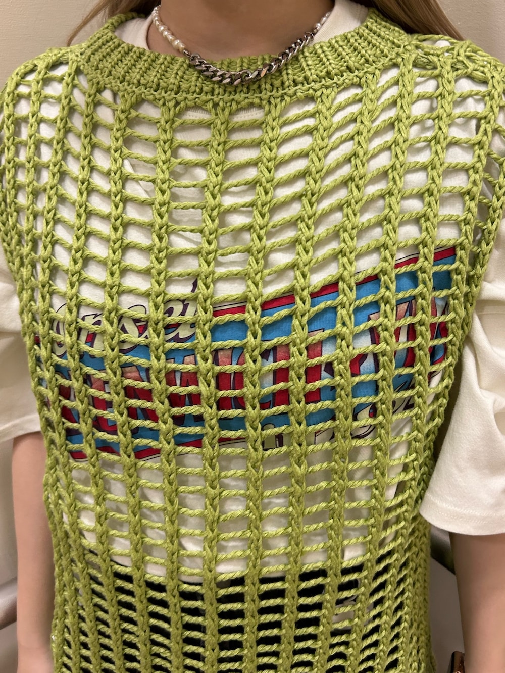 ホワイト系のTシャツ/カットソー、ブラック系のカーゴパンツ、グリーン系のベストを着用したレディースの春コーディネートの5枚目の写真