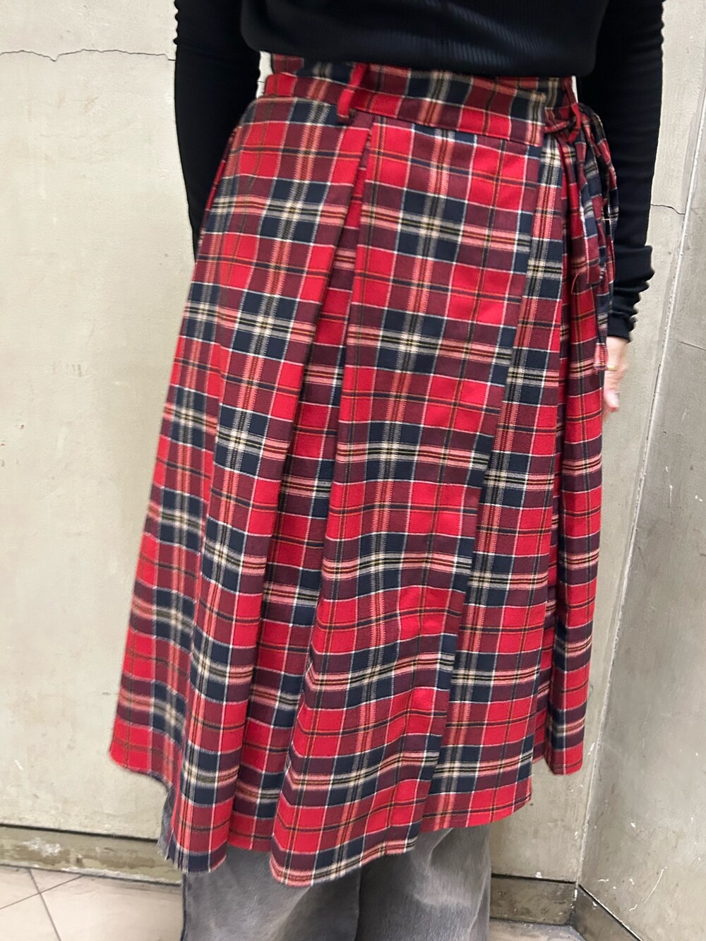 ブラック系のブーツ、ブラック系のTシャツ/カットソー、レッド系のスカートを着用したレディースの秋コーディネートの8枚目の写真