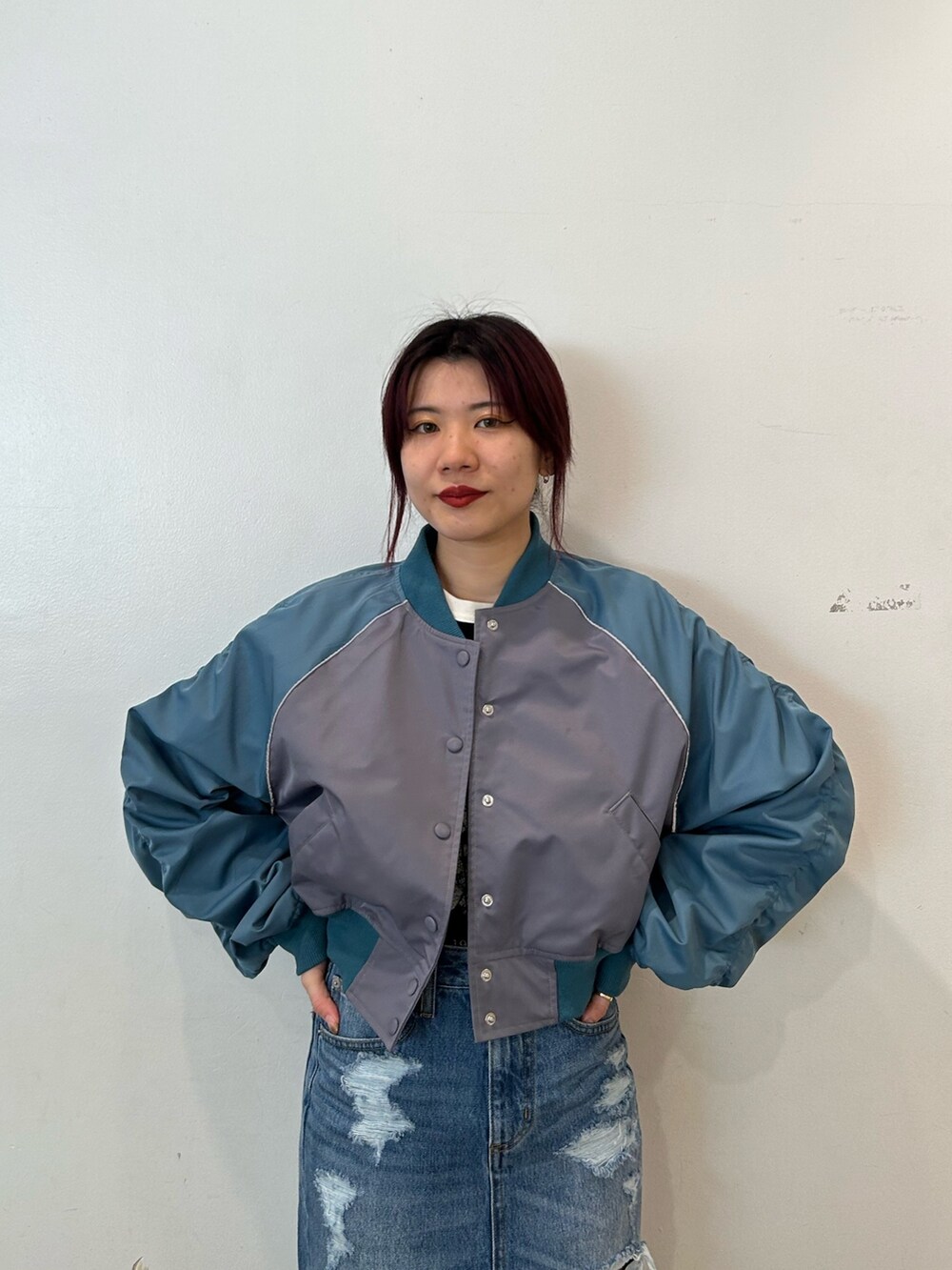 ブラック系のブーツ、グレー系のブルゾン、ブルー系のデニムスカートを着用したレディースの春コーディネートの4枚目の写真