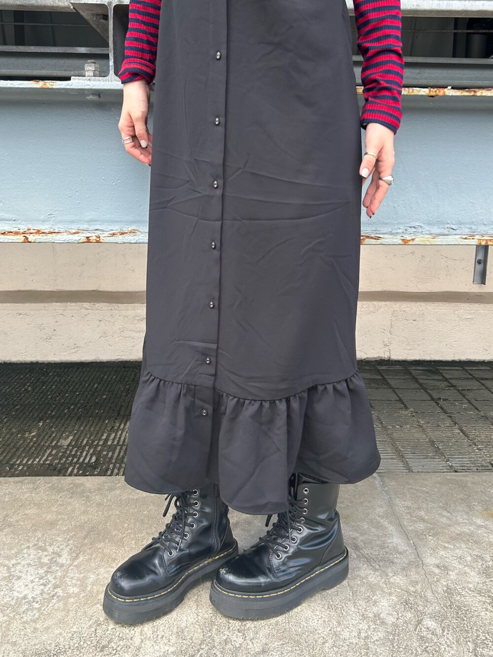 ブラック系のブーツ、ブラック系のワンピース、レッド系のTシャツ/カットソーを着用したレディースの夏コーディネートの6枚目の写真