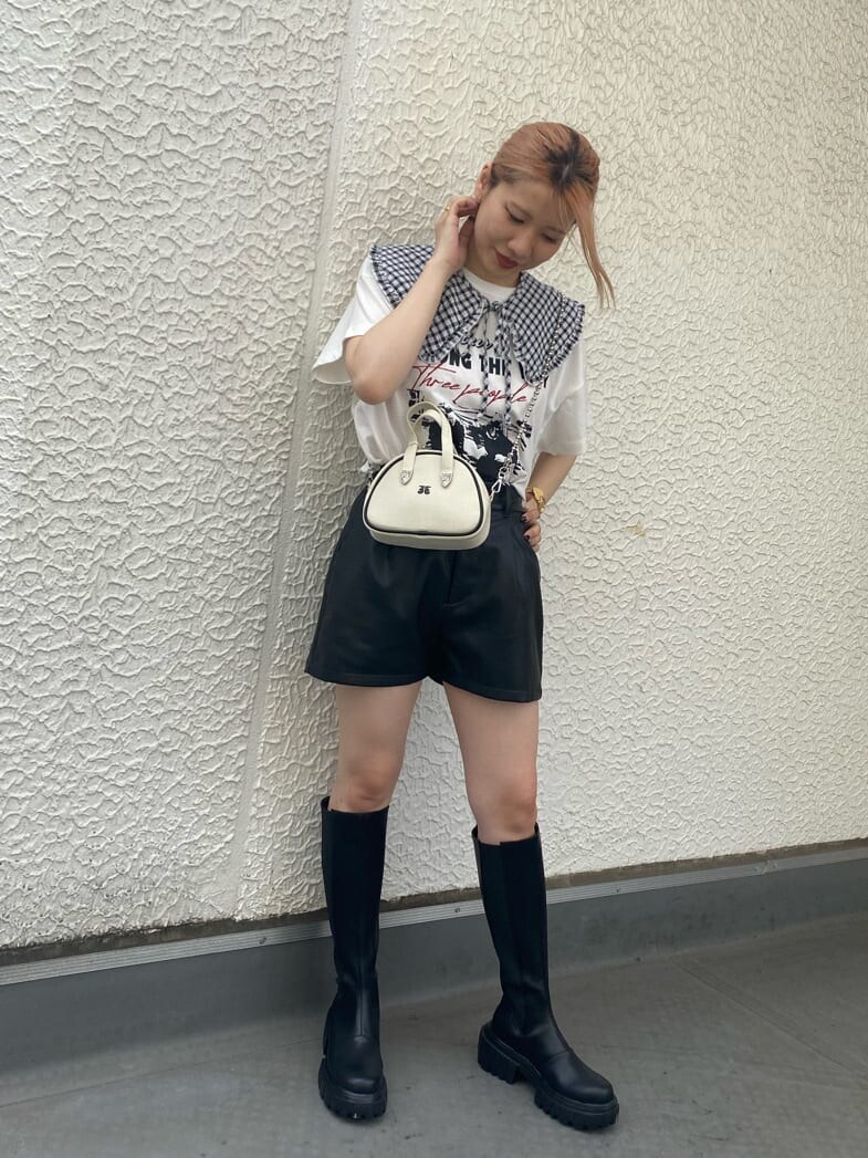 ブラック系のブーツ、ホワイト系のTシャツ/カットソー、ホワイト系のボストンバッグを着用したレディースの夏コーディネートの3枚目の写真