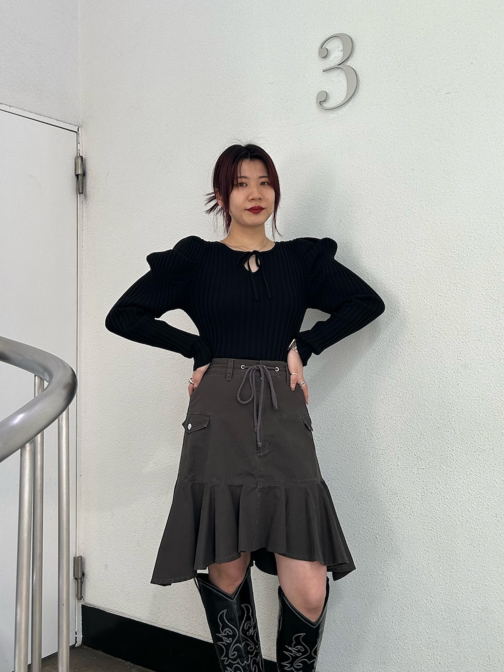 ブラック系のブーツ、ブラック系のスカート、ブラック系のニット/セーターを着用したレディースの冬コーディネートの4枚目の写真