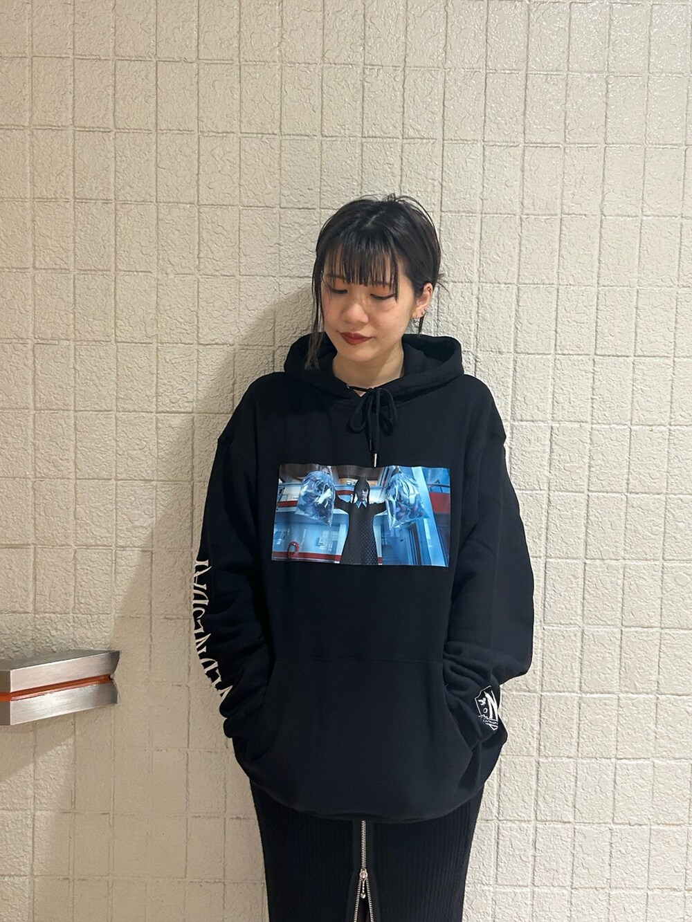 ブラック系のブーツ、ブラック系のスカート、ブラック系のパーカーを着用したレディースの秋コーディネートの5枚目の写真