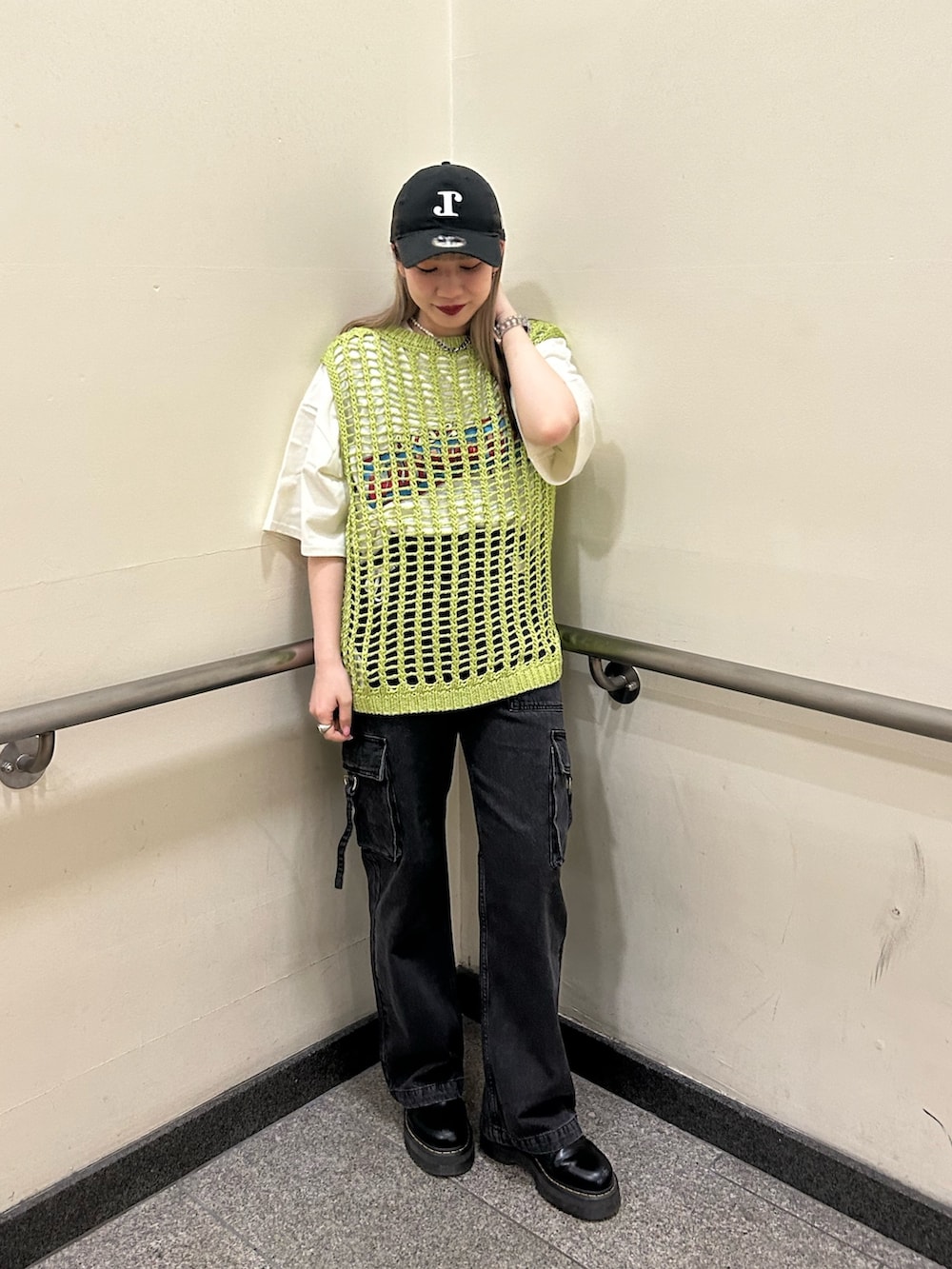 ホワイト系のTシャツ/カットソー、ブラック系のカーゴパンツ、グリーン系のベストを着用したレディースの春コーディネートの2枚目の写真