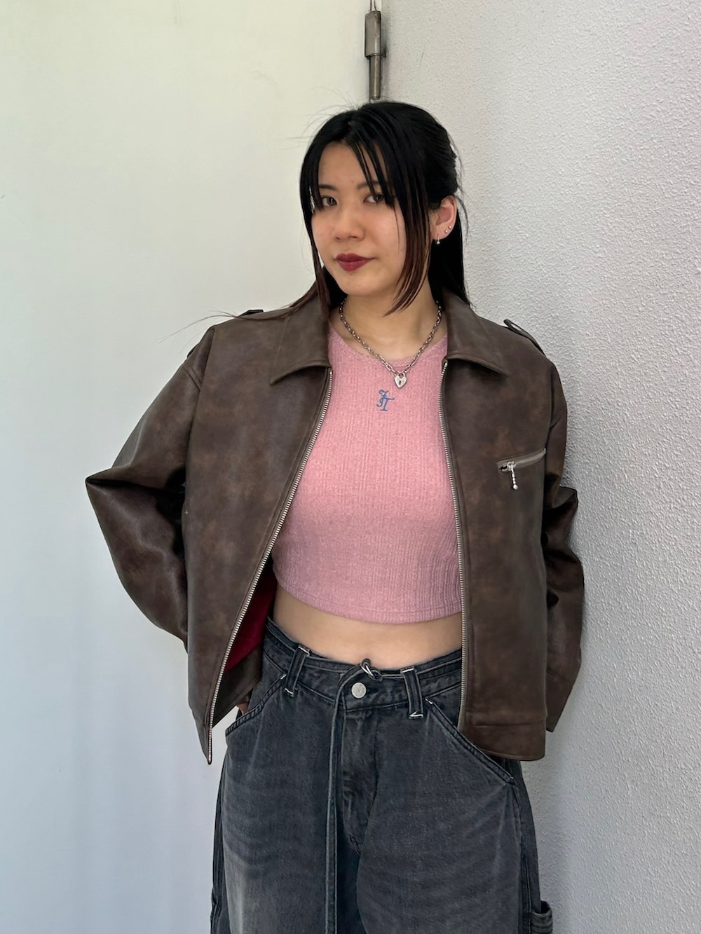 ブラック系のデニムパンツ、ホワイト系のスニーカー、ピンク系のTシャツ/カットソーを着用したレディースの夏コーディネートの4枚目の写真