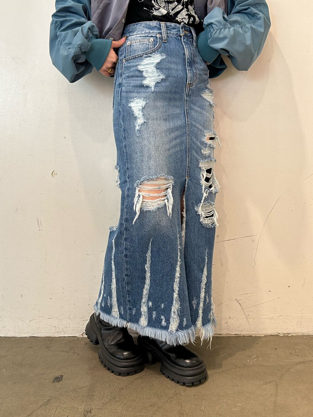 ブラック系のブーツ、グレー系のブルゾン、ブルー系のデニムスカートを着用したレディースの春コーディネートの6枚目の写真