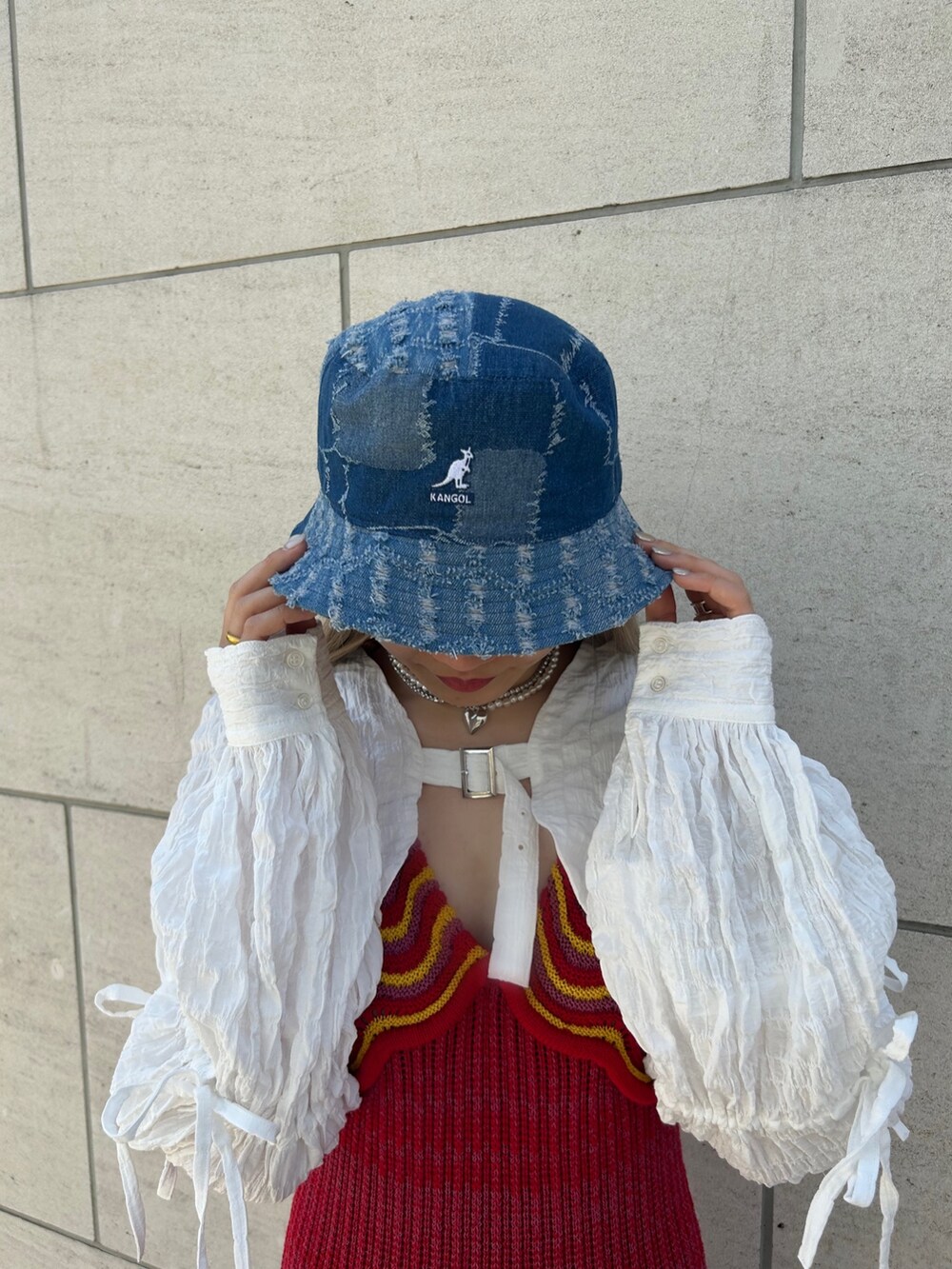 ブラック系のその他シューズ、ホワイト系のカーディガン/ボレロ、シルバー系のネックレスを着用したレディースの春コーディネートの4枚目の写真