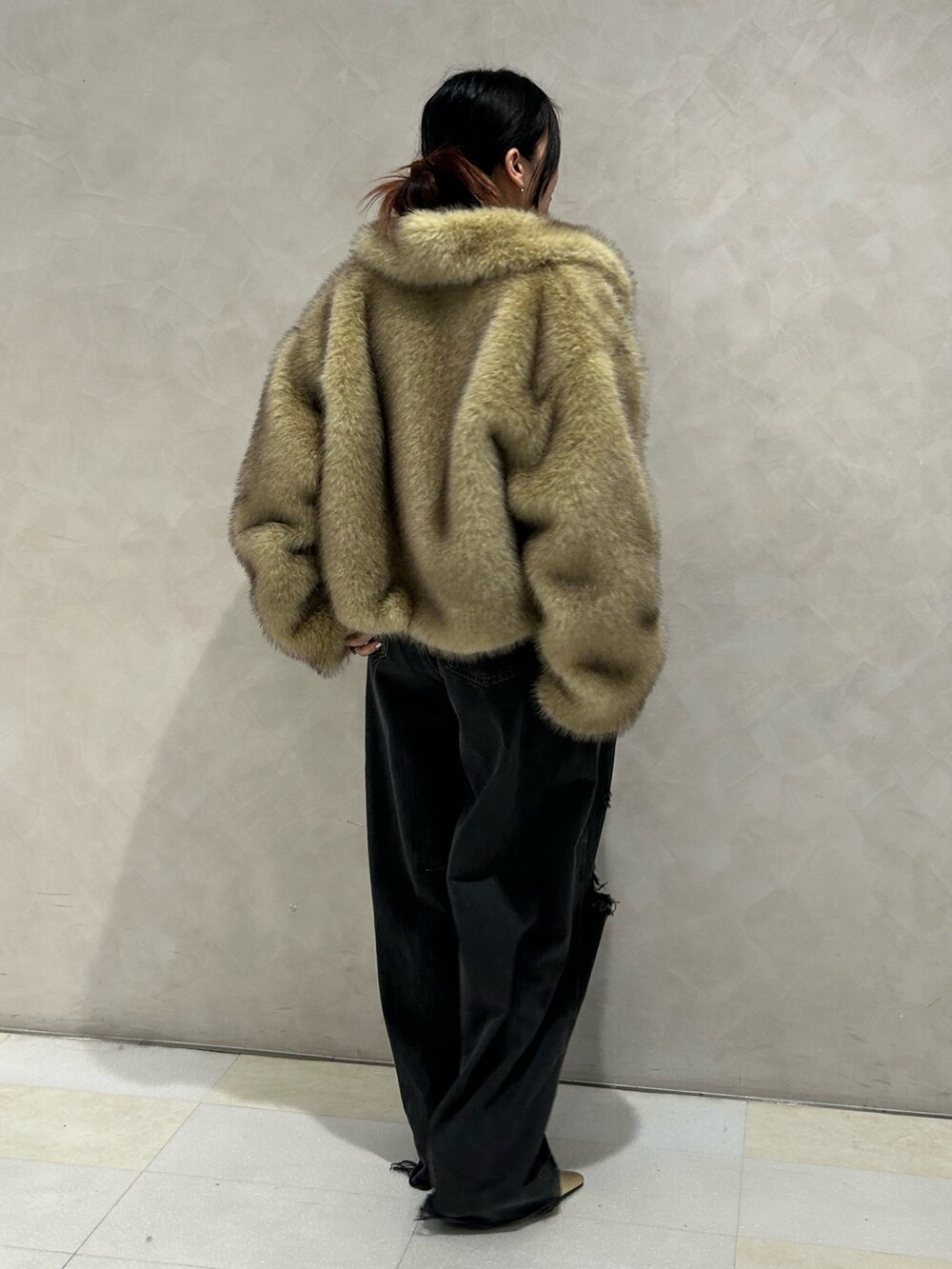 ブラック系のデニムパンツ、ゴールド系のパンプス、ブラック系のTシャツ/カットソーを着用したレディースの秋コーディネートの4枚目の写真