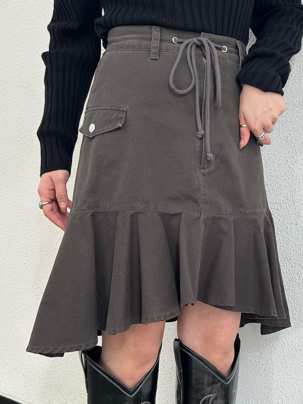 ブラック系のブーツ、ブラック系のスカート、ブラック系のニット/セーターを着用したレディースの冬コーディネートの7枚目の写真