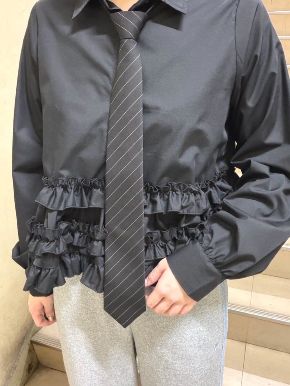 ブラック系のシャツ/ブラウス、ブラック系のパンプス、グレー系のその他パンツを着用したレディースの春コーディネートの5枚目の写真