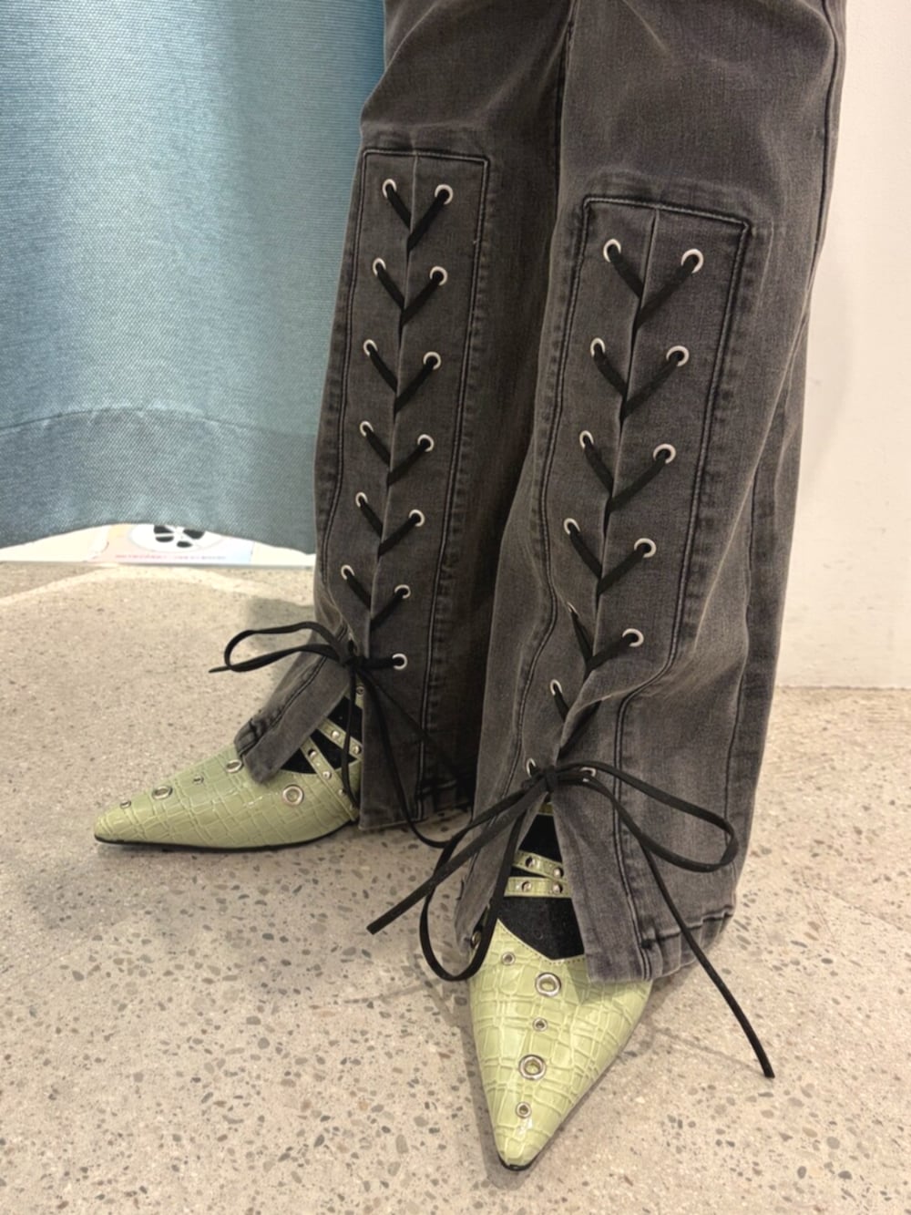 グリーン系のパンプス、ブラック系のデニムパンツ、ブラック系のワンピースを着用したレディースの春コーディネートの7枚目の写真