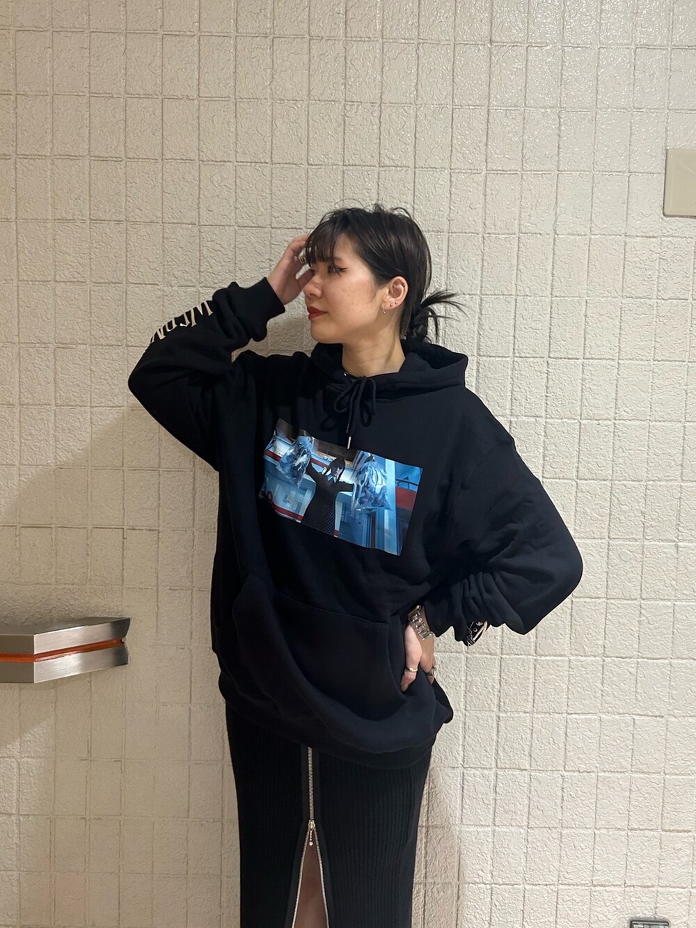 ブラック系のブーツ、ブラック系のスカート、ブラック系のパーカーを着用したレディースの秋コーディネートの6枚目の写真