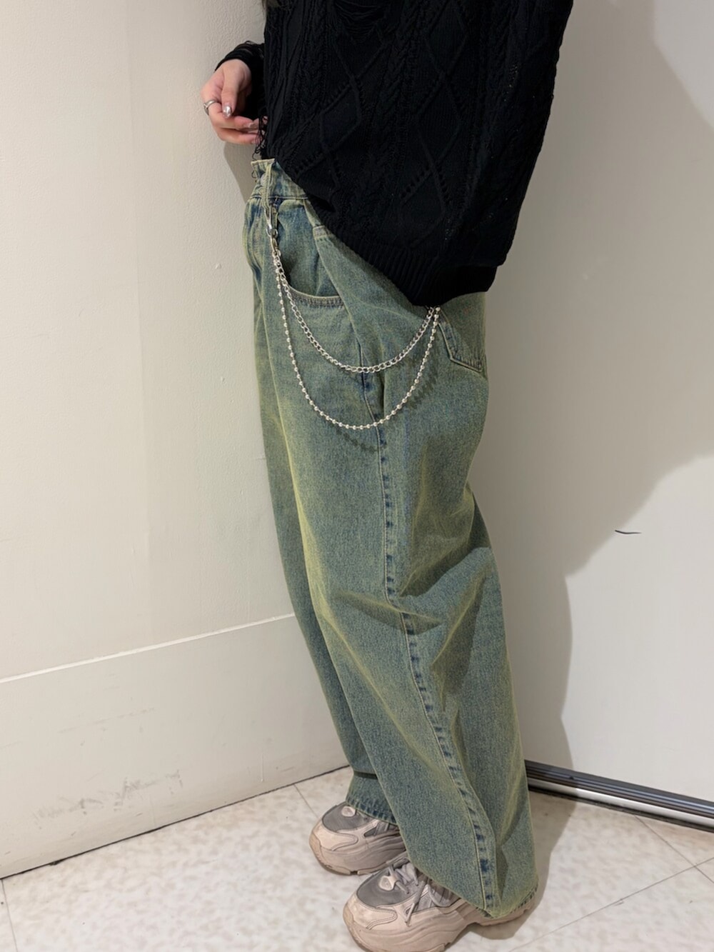 ブルー系のデニムパンツ、ブラック系のニット/セーター、シルバー系のネックレスを着用したレディースの春コーディネートの9枚目の写真
