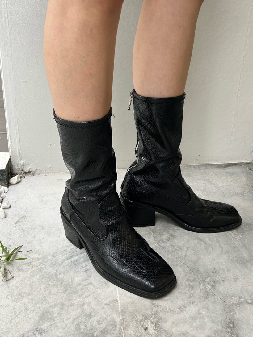 ブラック系のブーツ、ホワイト系のハンドバッグ、ブラック系のデニムパンツを着用したレディースの秋コーディネートの10枚目の写真