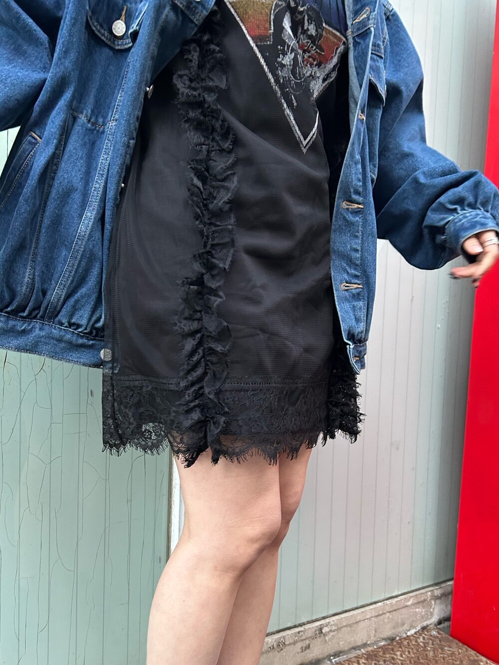 ブラック系のブーツ、ブラック系のワンピース、ブルー系のデニムジャケットを着用したレディースの春コーディネートの6枚目の写真