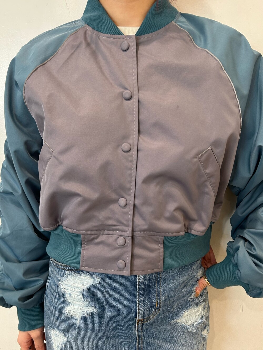 ブラック系のブーツ、グレー系のブルゾン、ブルー系のデニムスカートを着用したレディースの春コーディネートの7枚目の写真