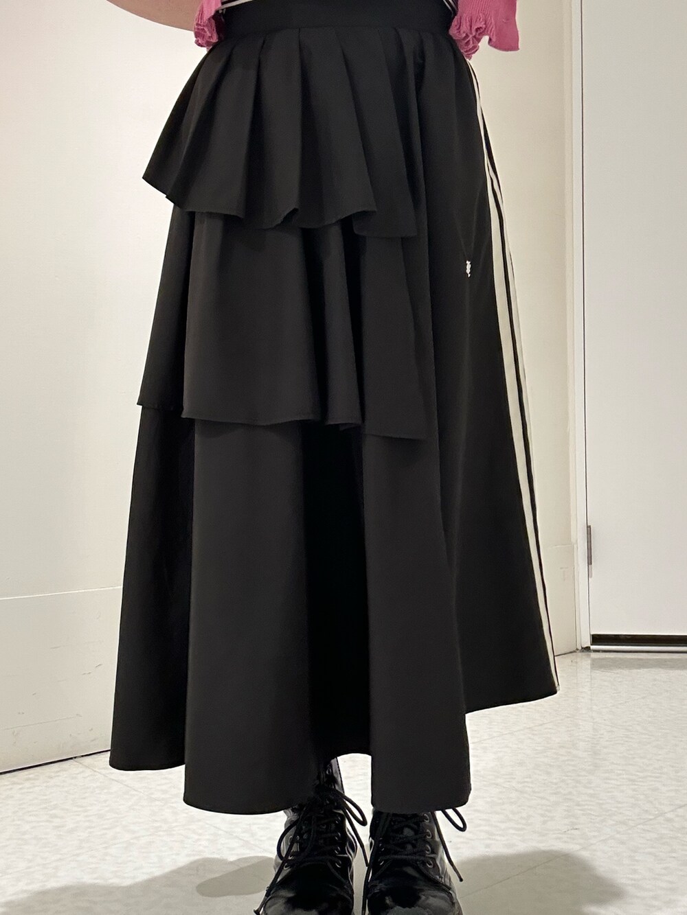 ブラック系のスカート、ブラック系のブーツ、ピンク系のカーディガン/ボレロを着用したレディースの春コーディネートの6枚目の写真