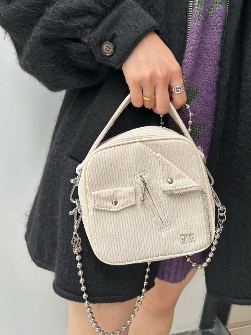 ブラック系のブーツ、ホワイト系のハンドバッグ、ブラック系のデニムパンツを着用したレディースの秋コーディネートの9枚目の写真