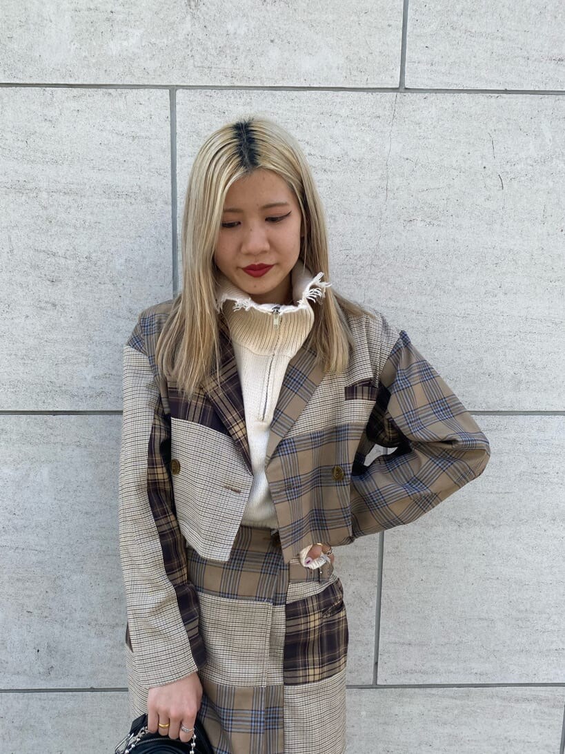 ブラック系のハンドバッグ、ブラック系のブーツ、ホワイト系のベストを着用したレディースの秋コーディネートの5枚目の写真