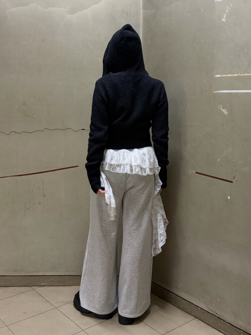 ブラック系のパーカー、グレー系のスウェットパンツ、ブラック系のローファーを着用したレディースの冬コーディネートの3枚目の写真