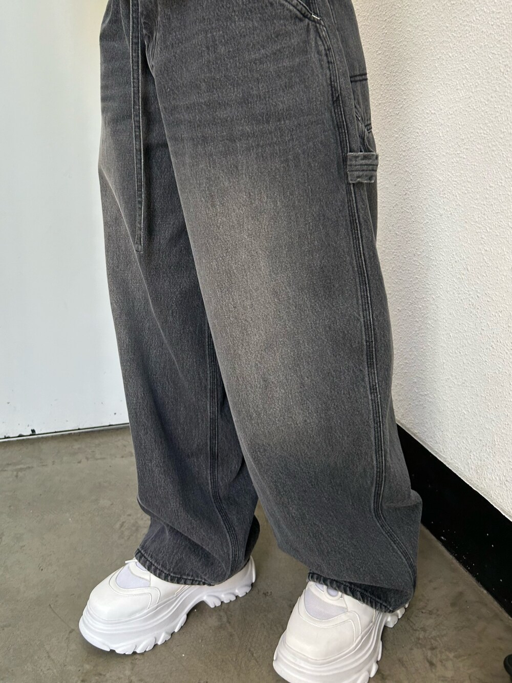 ブラック系のデニムパンツ、ホワイト系のスニーカー、ピンク系のTシャツ/カットソーを着用したレディースの夏コーディネートの8枚目の写真