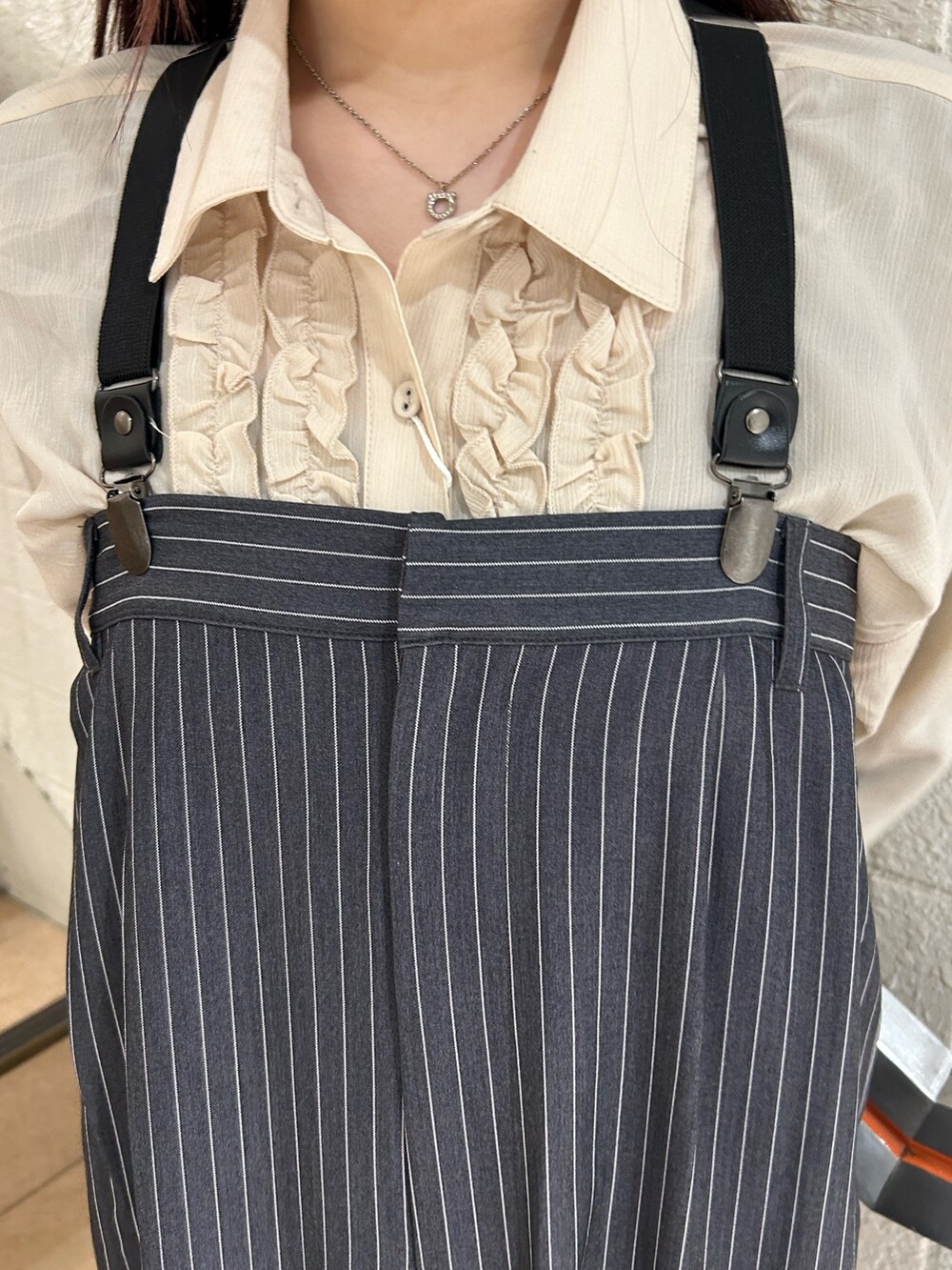 ブラック系のブーツ、ホワイト系のシャツ/ブラウス、グレー系のつなぎ/オールインワンを着用したレディースの冬コーディネートの6枚目の写真