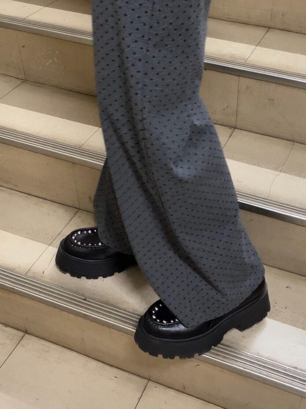 ブラック系のパーカー、グレー系のスウェットパンツ、ブラック系のローファーを着用したレディースの春コーディネートの7枚目の写真