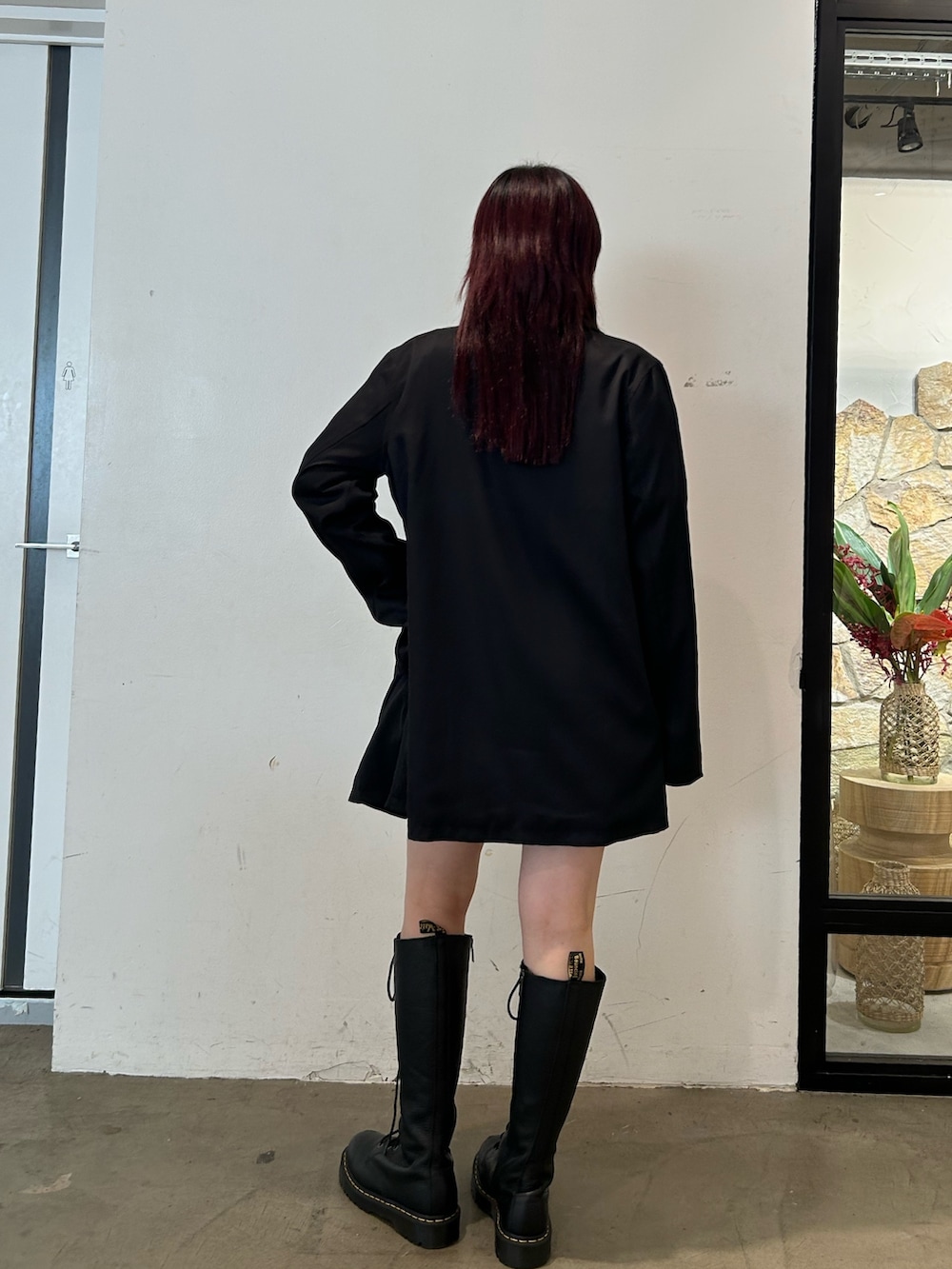 ブラック系のブーツ、ブラック系のデニムスカート、ブラック系のワンピースを着用したレディースの冬コーディネートの3枚目の写真