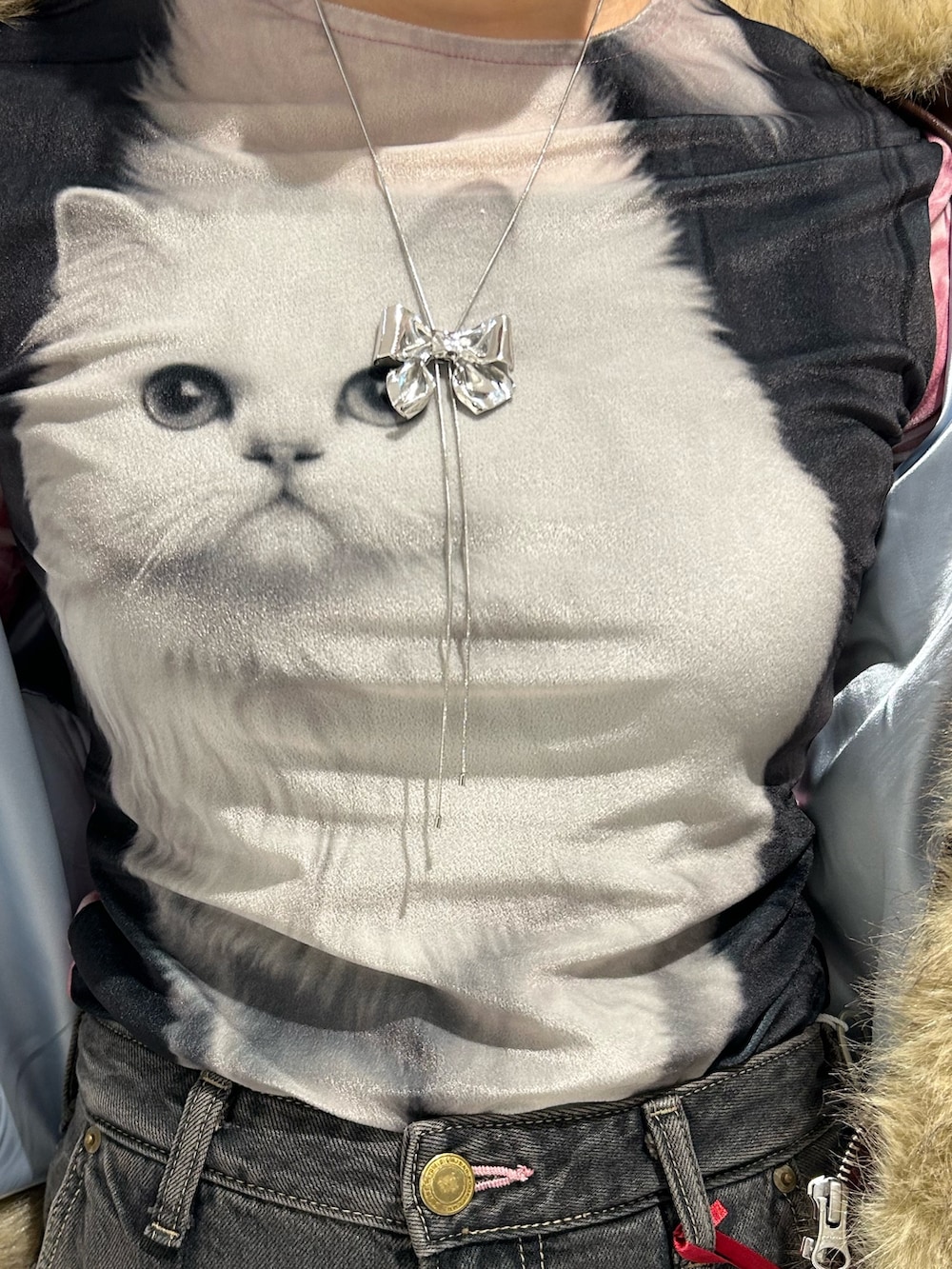 ブラック系のデニムパンツ、ゴールド系のパンプス、ブラック系のTシャツ/カットソーを着用したレディースの秋コーディネートの8枚目の写真