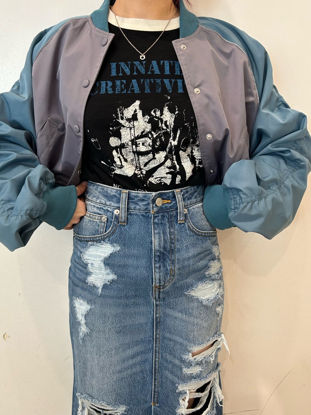 ブラック系のブーツ、グレー系のブルゾン、ブルー系のデニムスカートを着用したレディースの春コーディネートの5枚目の写真