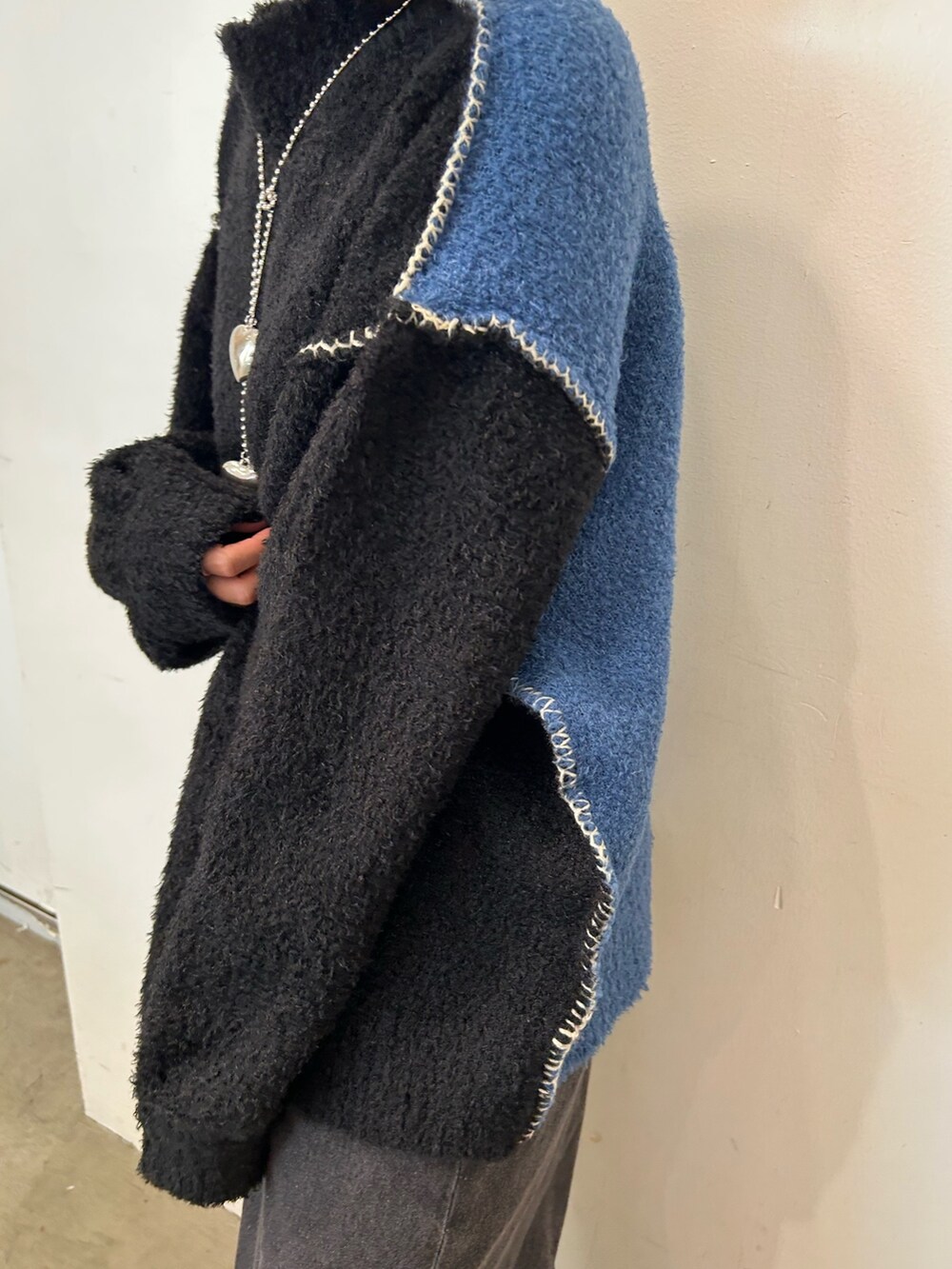 ブラック系のデニムパンツ、ブラック系のブーツ、ブラック系のニット/セーターを着用したレディースの秋コーディネートの5枚目の写真