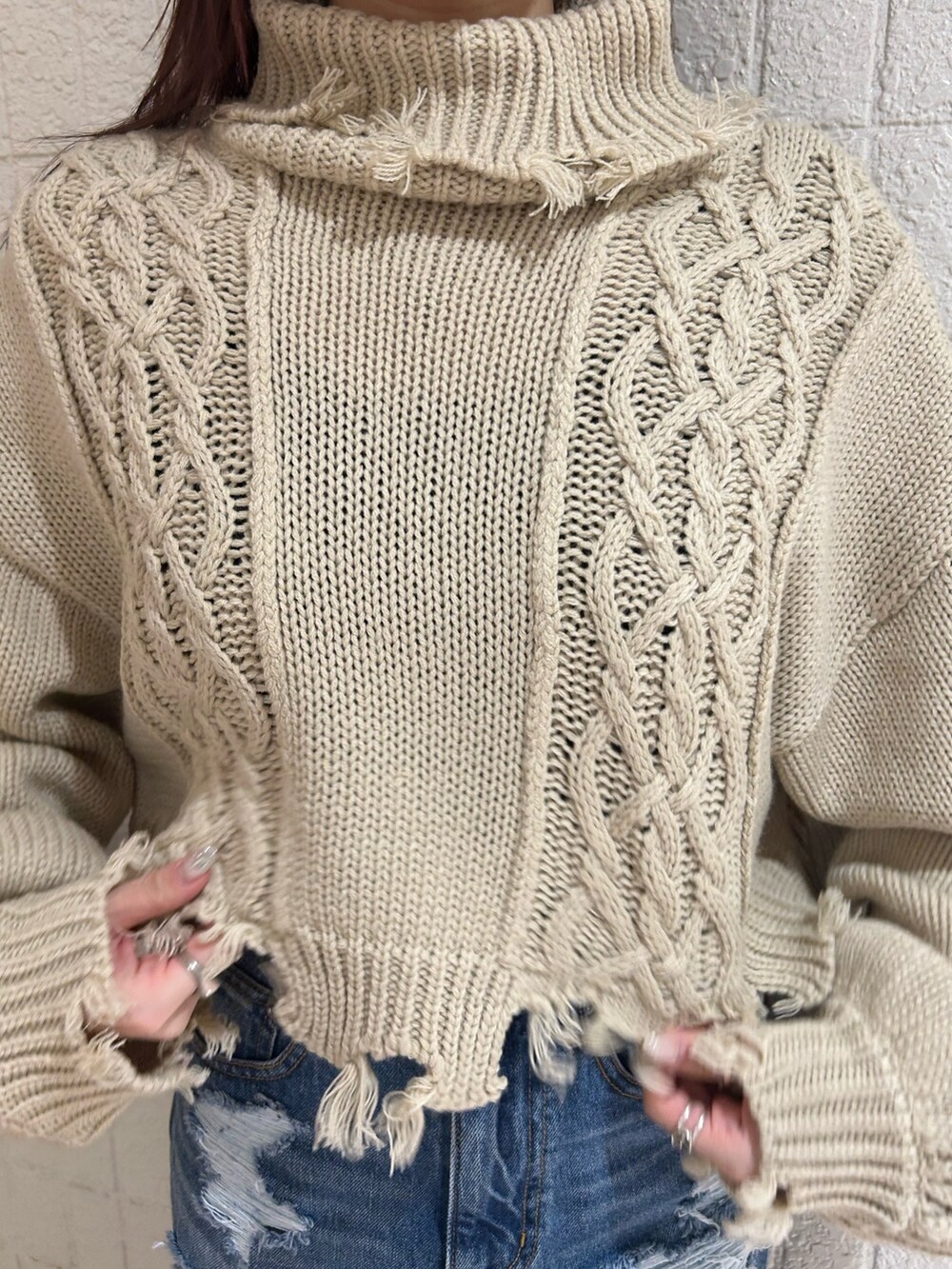 ブラック系のブーツ、ブルー系のデニムスカート、ホワイト系のニット/セーターを着用したレディースの冬コーディネートの6枚目の写真