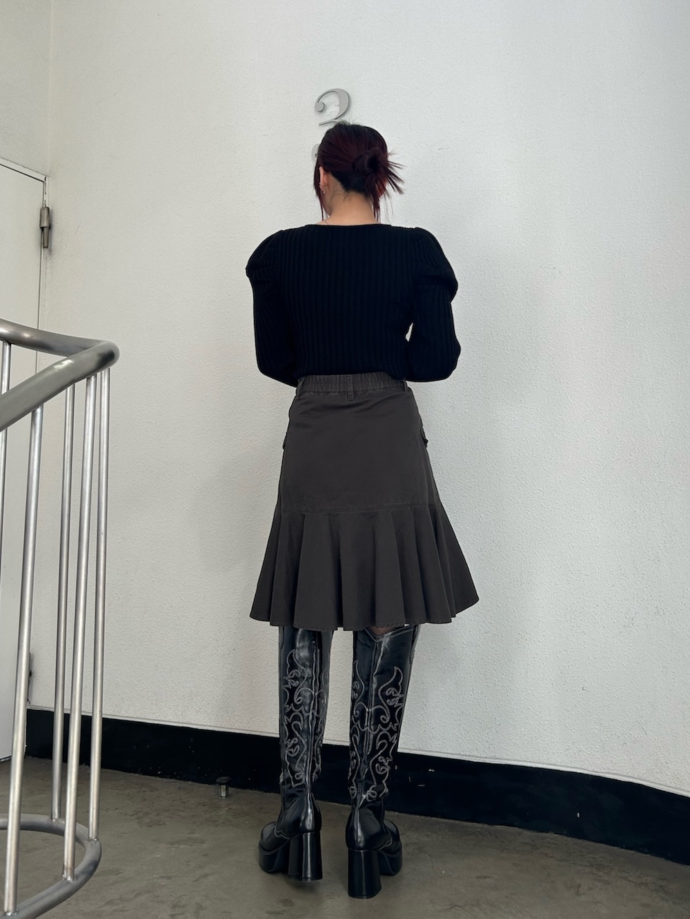 ブラック系のブーツ、ブラック系のスカート、ブラック系のニット/セーターを着用したレディースの冬コーディネートの3枚目の写真