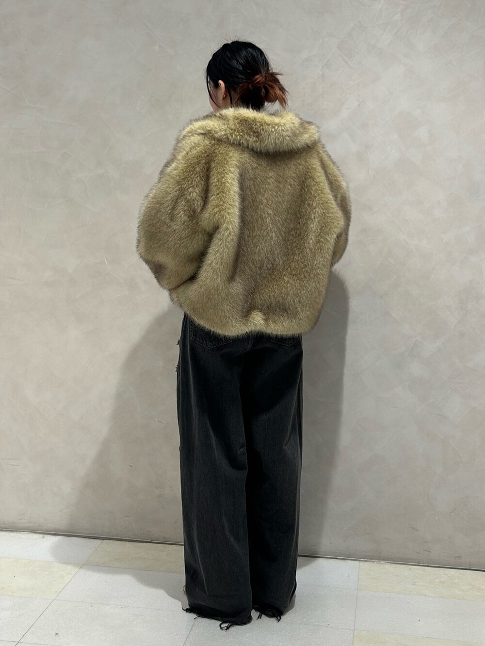 ブラック系のデニムパンツ、ゴールド系のパンプス、ブラック系のTシャツ/カットソーを着用したレディースの秋コーディネートの5枚目の写真