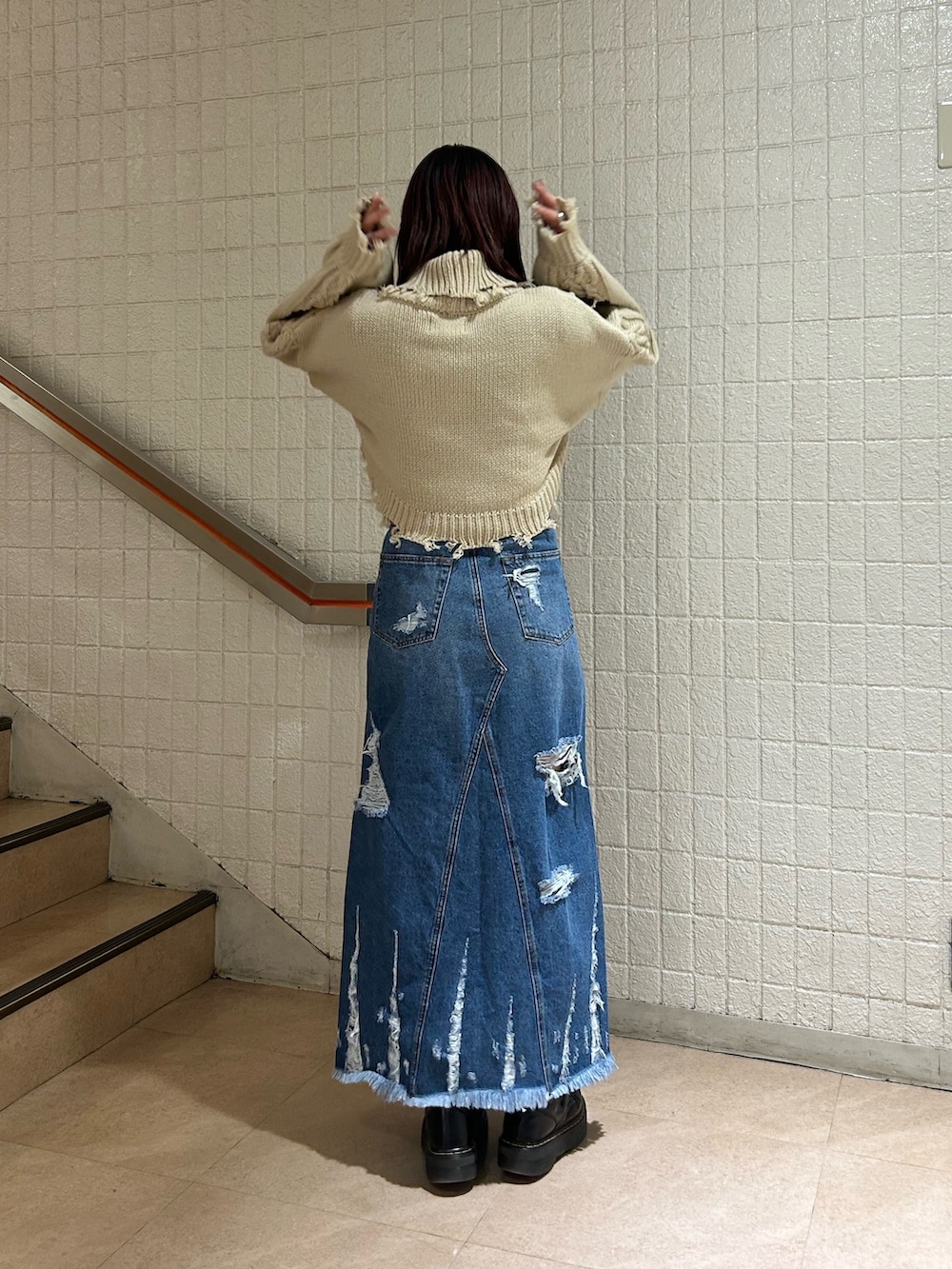 ブラック系のブーツ、ブルー系のデニムスカート、ホワイト系のニット/セーターを着用したレディースの冬コーディネートの3枚目の写真