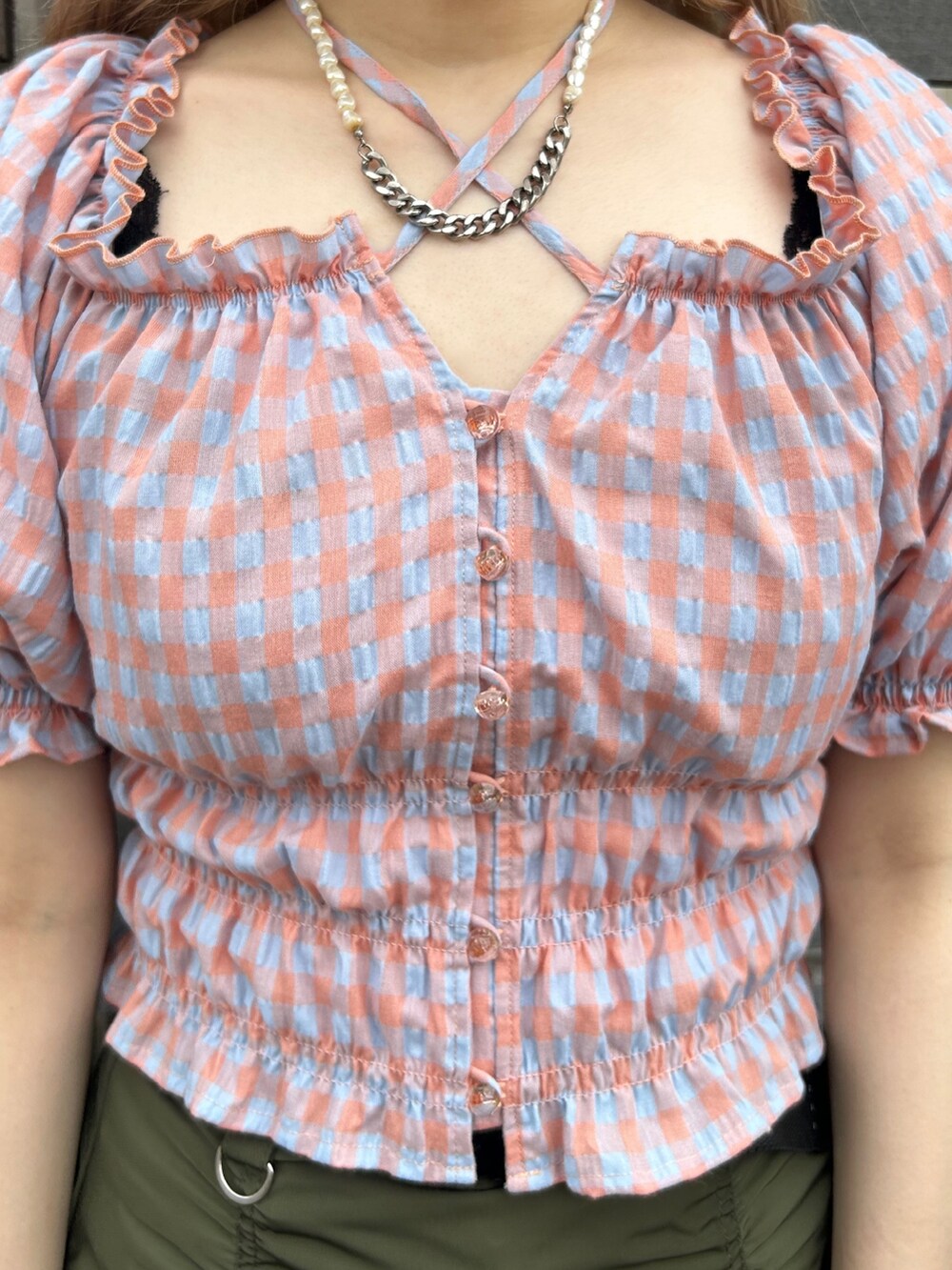 ブラック系のブーツ、オレンジ系のシャツ/ブラウス、グリーン系のスカートを着用したレディースの夏コーディネートの5枚目の写真