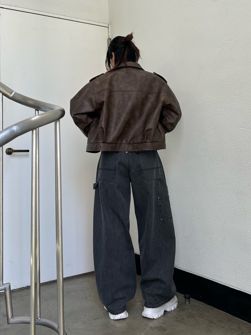 ブラック系のデニムパンツ、ホワイト系のスニーカー、ピンク系のTシャツ/カットソーを着用したレディースの夏コーディネートの3枚目の写真