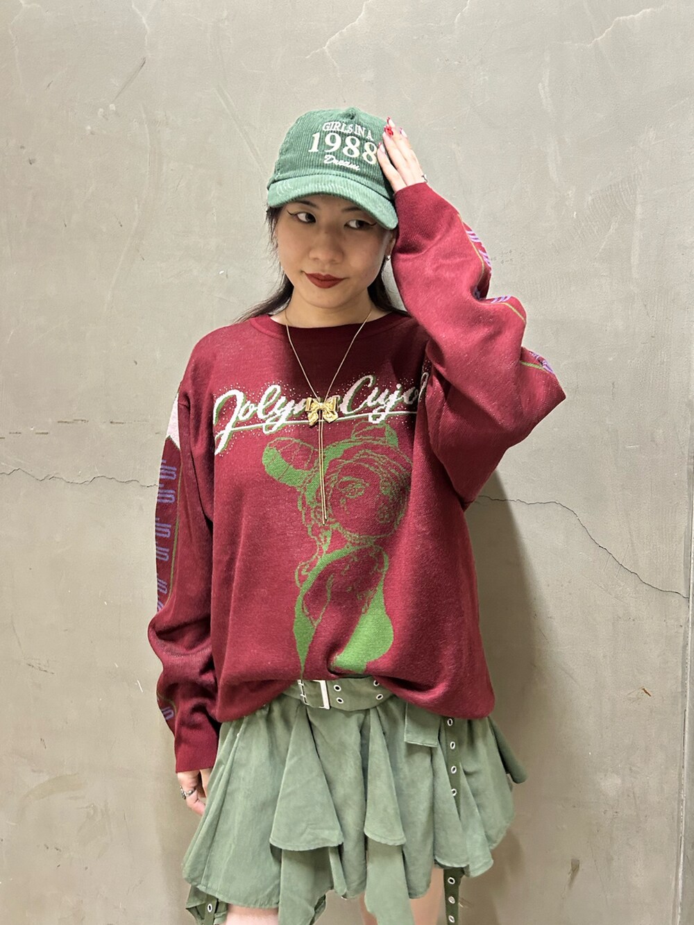 ブラック系のブーツ、レッド系のニット/セーター、グリーン系のスカートを着用したレディースの秋コーディネートの6枚目の写真