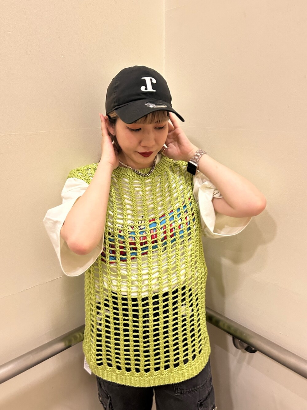 ホワイト系のTシャツ/カットソー、ブラック系のカーゴパンツ、グリーン系のベストを着用したレディースの春コーディネートの3枚目の写真